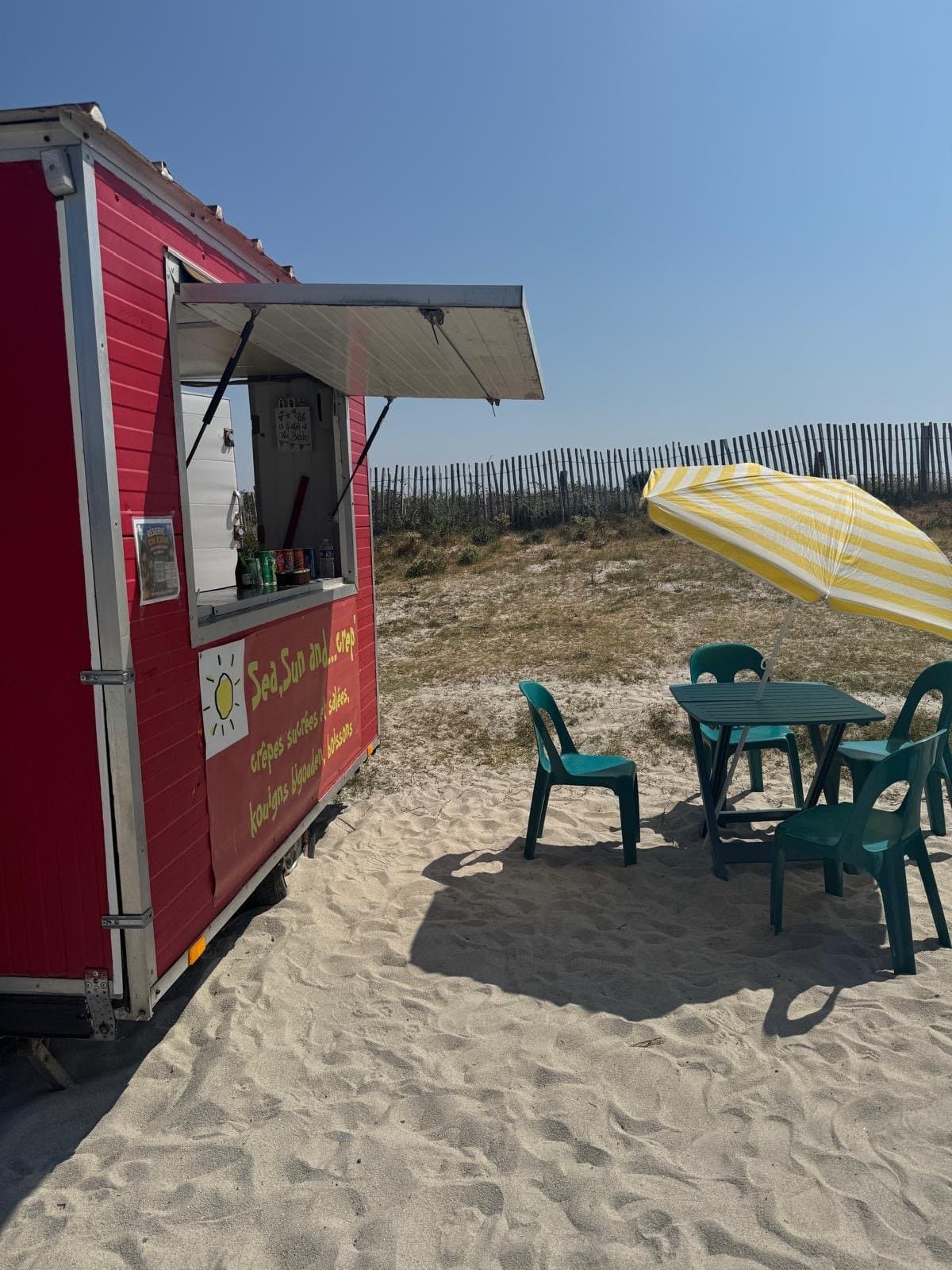 La remorque rouge « Sea, Sun and… Crêp’ » installée sur la plage du Steir, auvent ouvert et tables sous parasol.